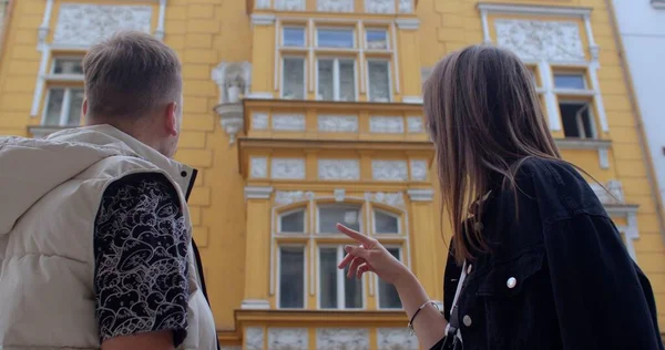 Турист и девушка обсуждают архитектурный фасад здания. — стоковое фото