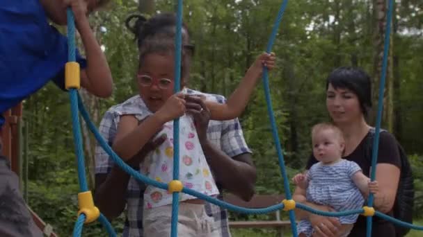 Padre aiuta sua figlia a superare un ostacolo fatto di corde. Crescere i bambini. — Video Stock