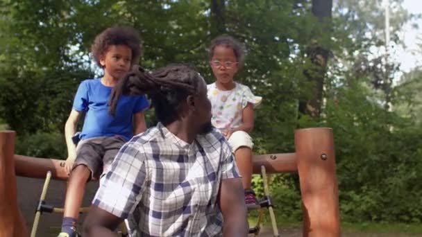 Fader afrikansk amerikan poserar barn stadspark visar gest, dreadlocks huvud — Stockvideo