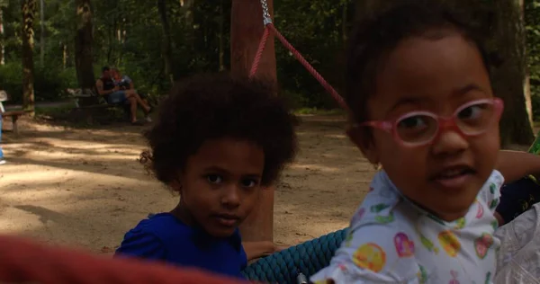 Barn rida på swing flicka med glasögon tittar på kameran Sommar semester — Stockfoto