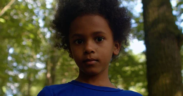 Portret van een jong Afrikaans-Amerikaans kind dat alleen door het park loopt. — Stockfoto