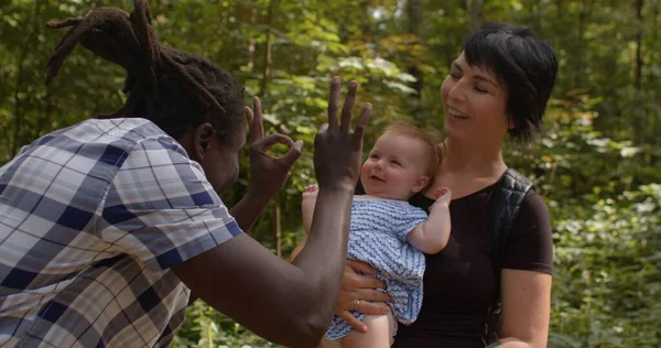 Mom meeting dad daughter. They in the forest, he makes movements with his hands