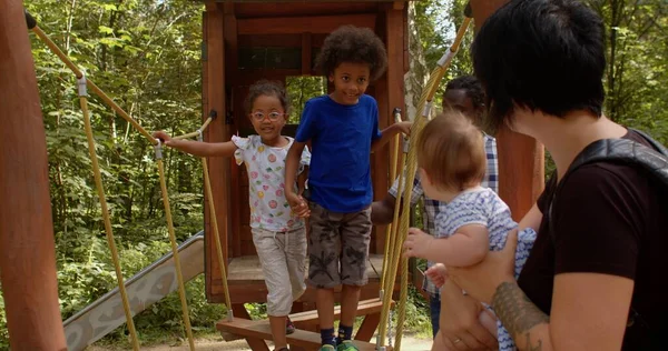 brother and sister walk holding hands. Parents with baby carefully observe child