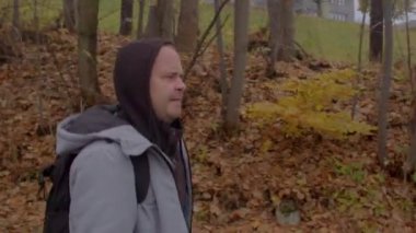 Adam şehir parkından geçiyor. Sarı yapraklı Bokeh 'e karşı.