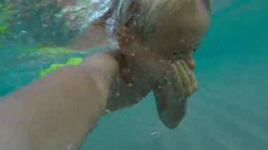 Bebek denizde dinlenirken, suyun içinde. Çocuk vücudu sertleştirme.