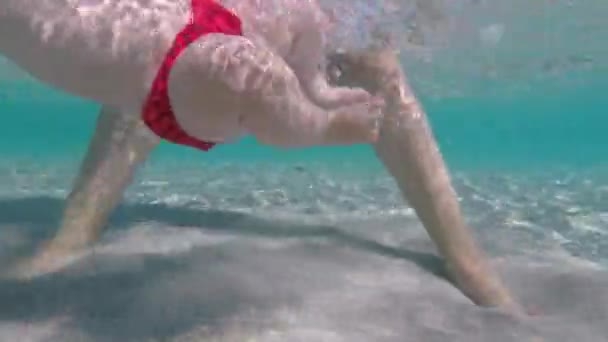 Bébé en maillot de bain rouge sous l'eau de la mer. Températion du corps de l'enfant. Former les enfants. — Video