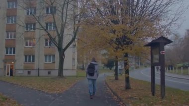 Sırt çantalı bir adamın sırtında, sonbaharda kaldırımda trafik vardı.. 