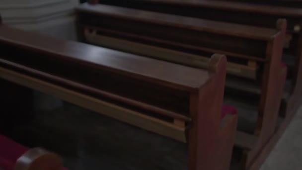 Ξύλινα παγκάκια στο χώρο της εκκλησίας για αρχάριους Καθολική θρησκεία. — Αρχείο Βίντεο