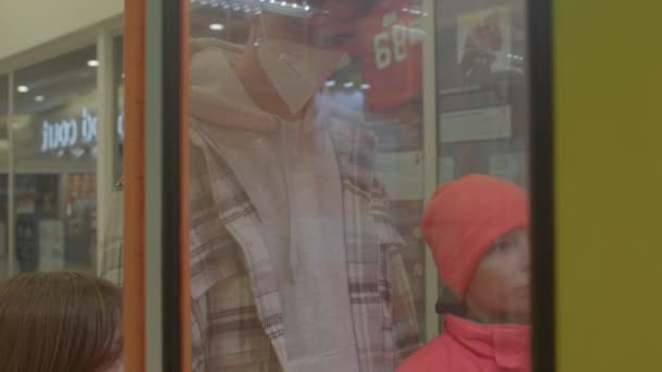 Young man children is standing near slot machine. They look through glass — Stock Video