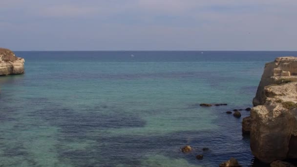 Zee baai in de stenen kust. Water maakt laservlekken. Rustig weer, blauwe luchten. — Stockvideo