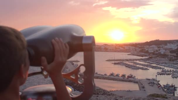 El niño mira al mar con una máquina expendedora binocular. Negocios de viajes por diversión. — Vídeos de Stock