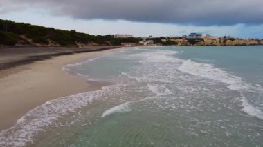 Deniz kıyısının ince kumu dalgalarla yıkanır. Üst görünümü uçur.