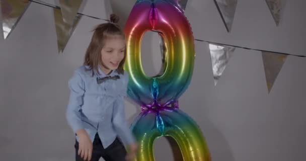 A criança pula chuta balões na celebração de aniversário. Desenvolvimento do crescimento emocional — Vídeo de Stock