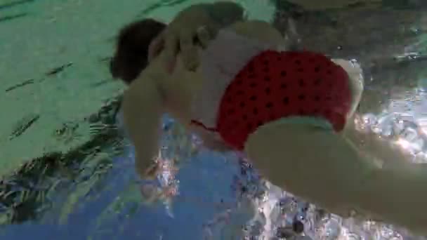 Cuerpo de bebé de nuevo bajo el agua del mar. La natación infantil es un fenómeno de bebés humanos. — Vídeos de Stock