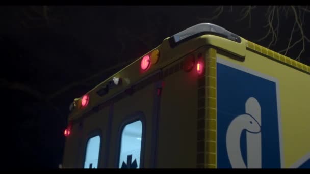 Ambulancia con luces intermitentes contra el cielo oscuro. Emergencia médica y salud. — Vídeo de stock