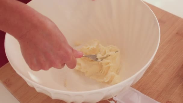 Hand utilise une fourchette mélangeant le sucre au beurre. Faire un bol de pâte crue. Village de cuisine maison. — Video