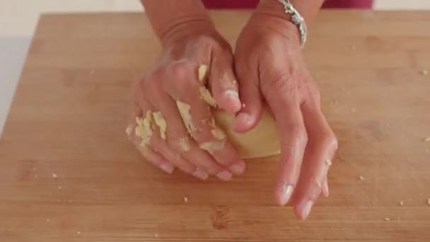 A szakács keze gyúrja a tésztát egy fapadlóra.. — Stock videók
