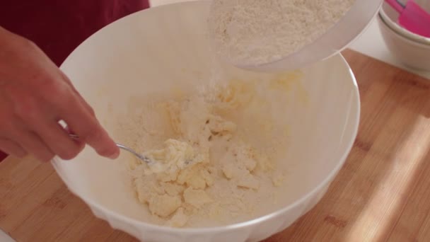 Рука готує починає готувати тісто. Вона вливає борошно в миску, готову сковороду — стокове відео