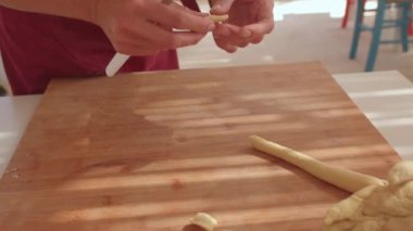 Bıçakla hamur doğramak. Elle pişirmek gemide hamuru keser. Parçaları kesiyor.