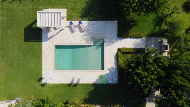 Piscina vazia de água. Há espreguiçadeiras na costa. Grama cresce ao redor. — Vídeo de Stock