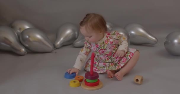 Using wooden ring stacker. Baby girl playing with pyramid educational toy. — Stock Video