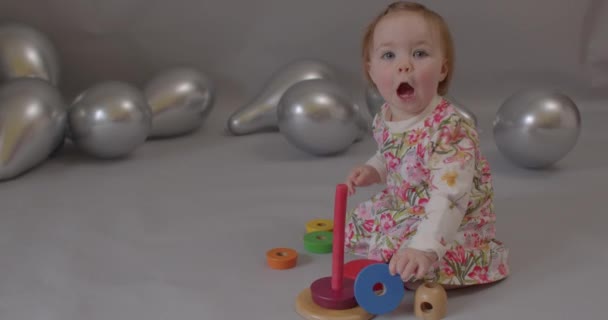 Bebé jugando con pirámide de color en la fiesta. Tratar a los bebés mediante terapia de juego. — Vídeo de stock