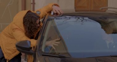 Cam sürücü arabasıyla konuşan bir adam koltuğunu bırakır ve direksiyona geçer.