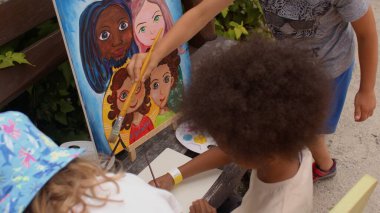 Çocuklar için açık havada resim dersi. Çocuklar açık havada boyayla resim yaparlar..