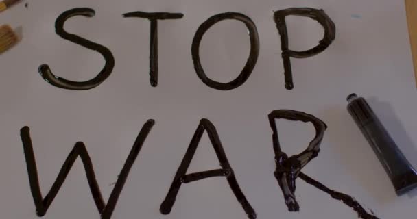 Barışı desteklemek için el yapımı savaş posterini durdurun. Beyaz kağıda siyah kelimeler yazar. — Stok video
