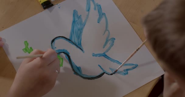 Handen schilderen de poster duif en olijftak af als symbool van vrede en onschuld — Stockvideo