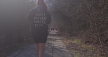 Woman jogging in city park in spring. Visits nature areas have positive effects.
