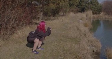 Kıyı gölünde mekik egzersizi yapan bir kız. Bacaklarını antrenmanda çalıştırıyor.