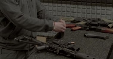 Eğitmen şarjörleri doldurur, cephaneyi parmaklarıyla yönetir.