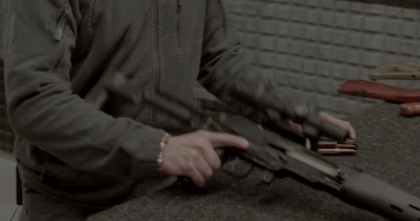 Muž nabíjí zásobník puškou. Škubne okenicí, podívá se do optického dohledu. — Stock video