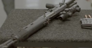 Masanın üzerinde farklı türde ateşli silahlar var. Dükkânın yanındaki cephane..