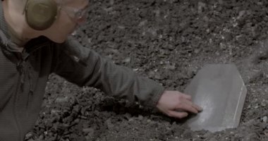 Eğitmen çelik yeleğin metal plakasını inceliyor..