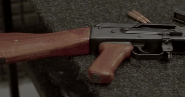 AK 74 lies on table without magazine. Wooden surfaces hand use. Damaged parts. — ストック動画