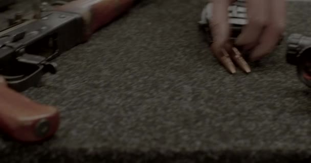 Рука инструктора указывает картриджи лежачие стол рядом с винтовкой с оптическим прицелом — стоковое видео