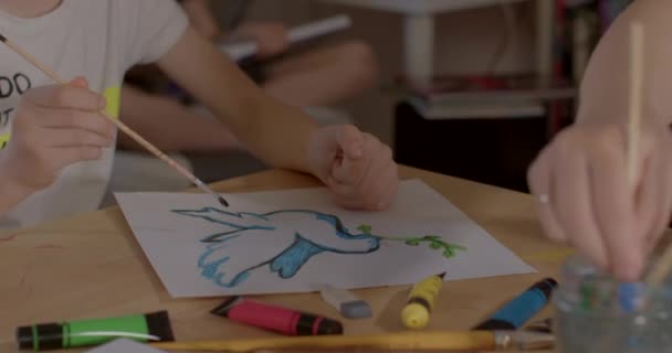 Pennello fa linea mani adolescente e insegnante disegnare poster colomba di pace — Video Stock