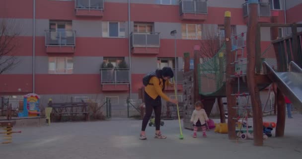 ママは赤ちゃんの女の子の遊び場にブラシを渡しますセット例動機 — ストック動画