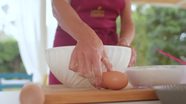 Primer plano de un cocinero que agrieta un huevo de gallina. Uso de huevos crudos en la cocción. — Vídeo de stock