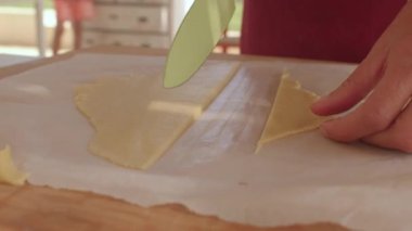 Ellerin yakın çekimi hamuru şeritler halinde keser. İtalyan crostata adım adım.