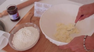 Üretim için hazırlanan hamur. Uzman malzemeyi çatalla karıştırıyor.