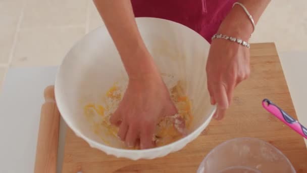 Προετοιμασία ζύμης για την παρασκευή μακαρονιών. Γυρίζοντας με το χέρι αναμιγνύει το αυγό και το αλεύρι — Αρχείο Βίντεο