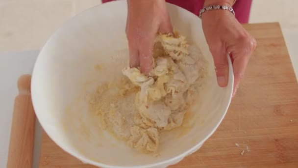 Une main de voleur fait de la pâte dans une assiette. Mélanger les ingrédients à la main. — Video