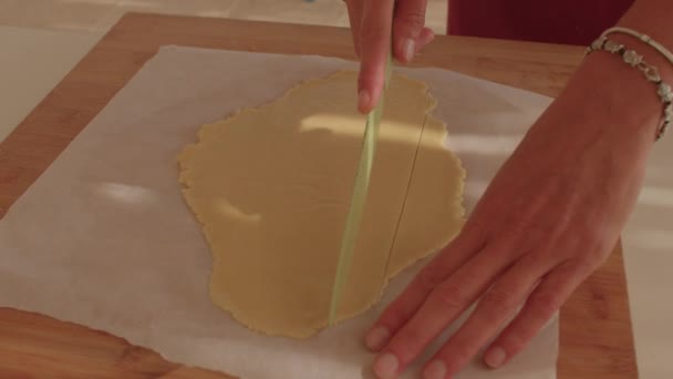 Membuat kue manis dengan tangan Anda. Tangan memotong adonan dengan strip meletakkannya siap — Stok Video