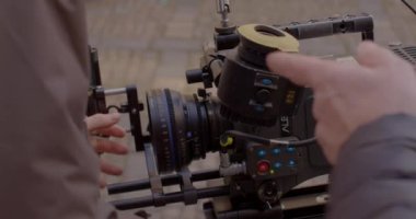 Yönetmen göz merceğine bakar. Operatör elleri kamera modülleri kullanır