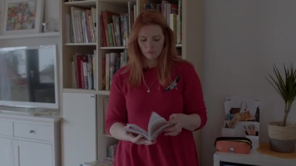 Woman with book in home library. Combining online and offline useful knowledge. — ストック動画