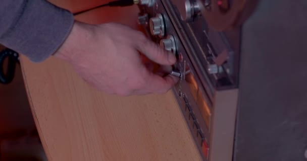 Close-up hand turns on and off of old electronic reel-to-reel tape recorder. — Stok Video