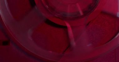 Kırmızı ışıkta eski bir teypte film olan bir makaranın hareketi..